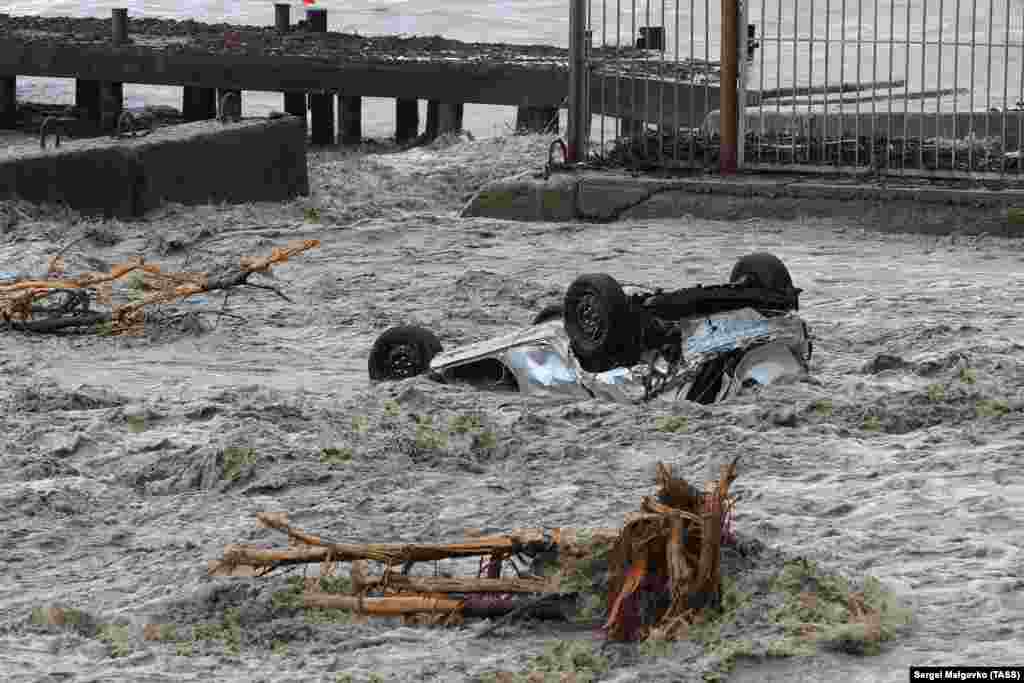 Автомобиль, вынесенный потоком воды на городскую набережную Ялты, Крым, 18 июня